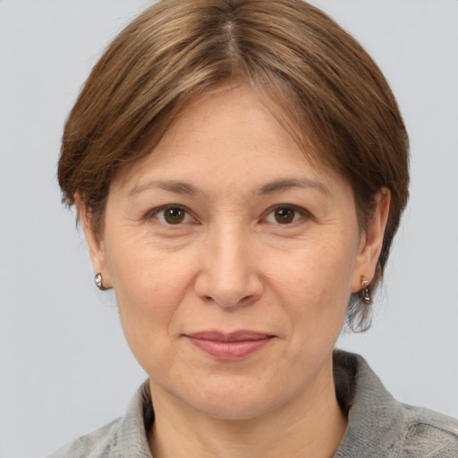 Joyful white adult female with medium  brown hair and grey eyes