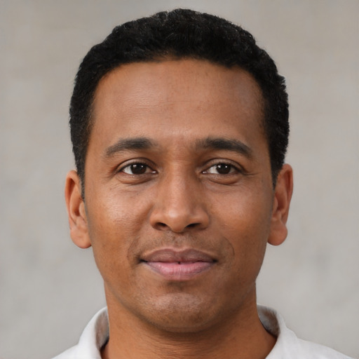 Joyful latino young-adult male with short  brown hair and brown eyes