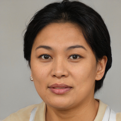 Joyful asian adult female with medium  brown hair and brown eyes