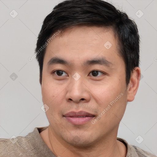 Joyful asian young-adult male with short  black hair and brown eyes