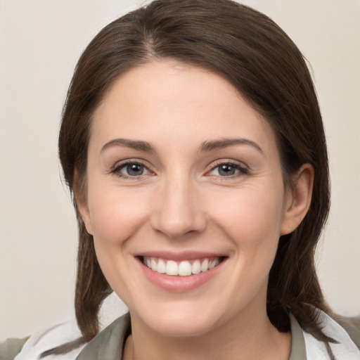 Joyful white young-adult female with medium  brown hair and grey eyes