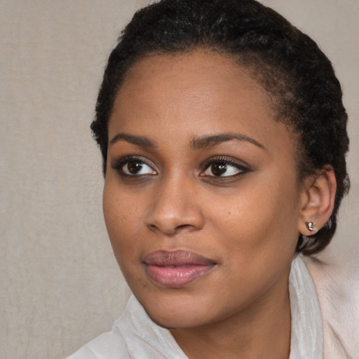 Joyful black young-adult female with short  black hair and brown eyes