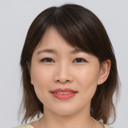 Joyful asian young-adult female with medium  brown hair and brown eyes