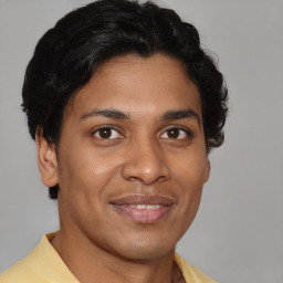 Joyful latino young-adult male with short  brown hair and brown eyes