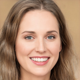 Joyful white young-adult female with long  brown hair and green eyes