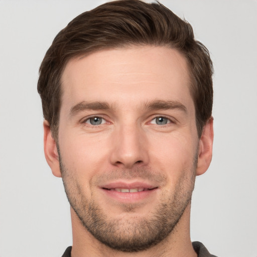 Joyful white young-adult male with short  brown hair and grey eyes