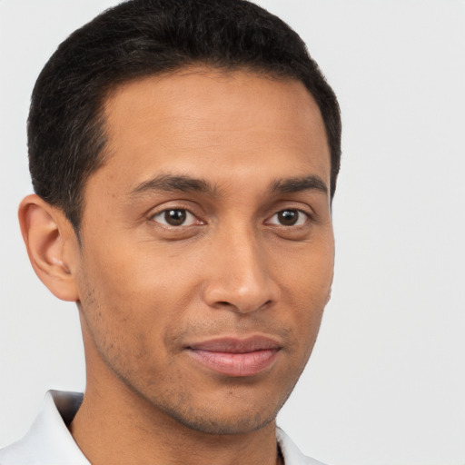 Joyful latino young-adult male with short  brown hair and brown eyes