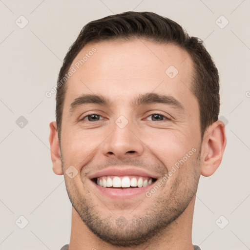 Joyful white young-adult male with short  brown hair and brown eyes