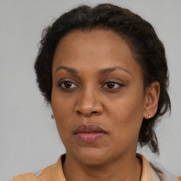 Joyful latino adult female with medium  brown hair and brown eyes