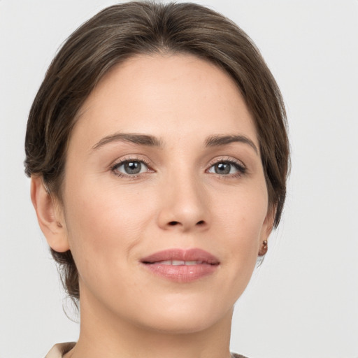 Joyful white young-adult female with medium  brown hair and grey eyes