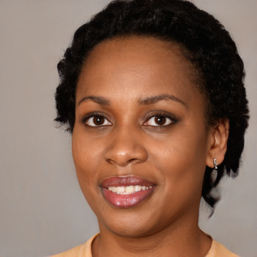 Joyful black young-adult female with medium  black hair and brown eyes