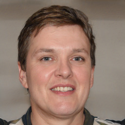 Joyful white adult male with short  brown hair and grey eyes