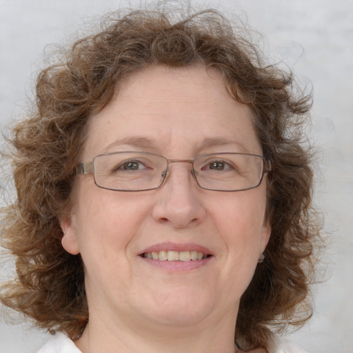 Joyful white middle-aged female with medium  brown hair and blue eyes