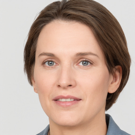 Joyful white adult female with medium  brown hair and grey eyes