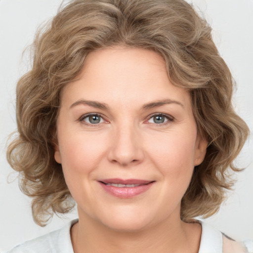 Joyful white young-adult female with medium  brown hair and green eyes