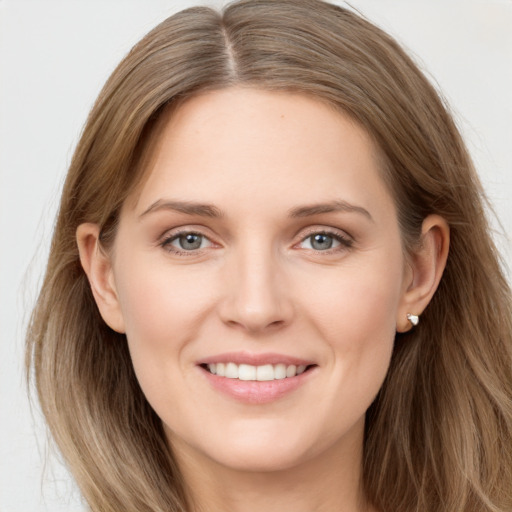 Joyful white young-adult female with long  brown hair and grey eyes