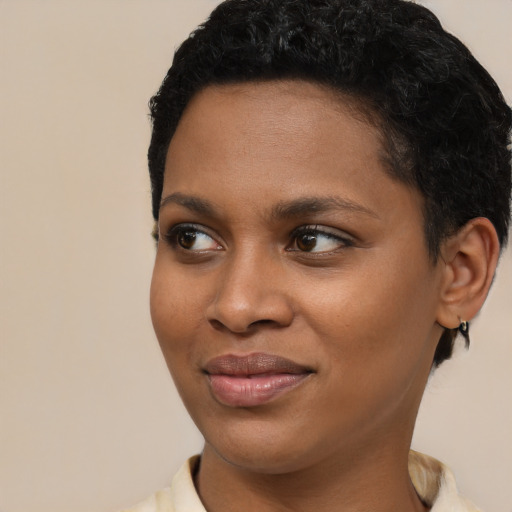 Joyful black young-adult female with short  black hair and brown eyes