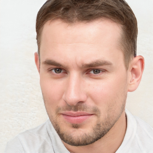 Joyful white young-adult male with short  brown hair and blue eyes