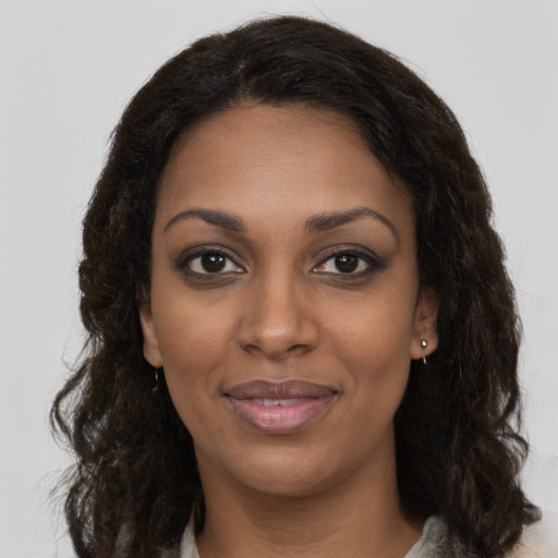 Joyful black young-adult female with long  brown hair and brown eyes