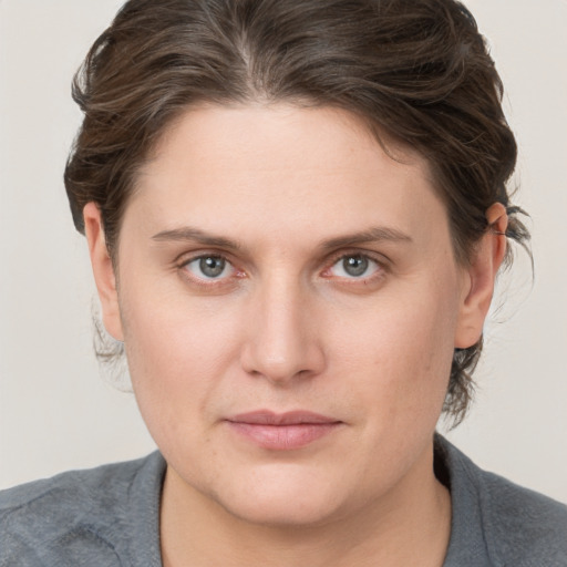 Joyful white young-adult female with medium  brown hair and blue eyes