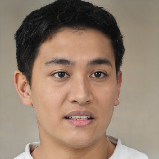 Joyful latino young-adult male with short  brown hair and brown eyes