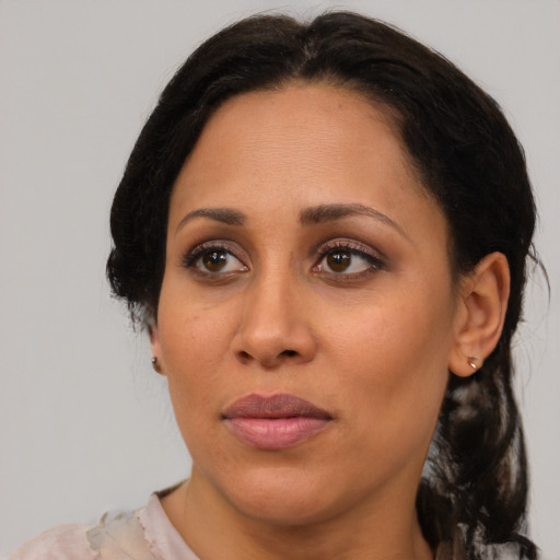 Joyful latino adult female with medium  brown hair and brown eyes