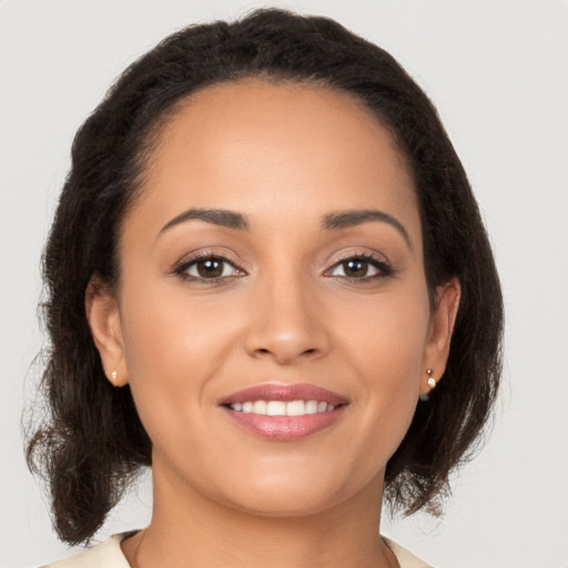 Joyful latino young-adult female with medium  brown hair and brown eyes