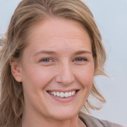 Joyful white young-adult female with long  brown hair and blue eyes