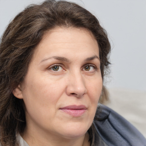 Joyful white adult female with long  brown hair and brown eyes