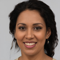 Joyful latino adult female with medium  brown hair and brown eyes