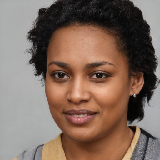 Joyful black young-adult female with medium  black hair and brown eyes