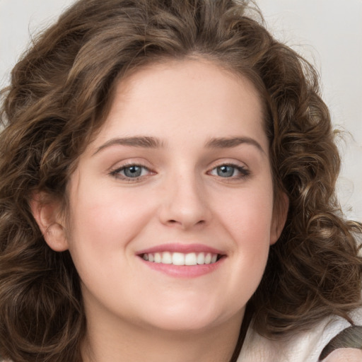 Joyful white young-adult female with long  brown hair and green eyes