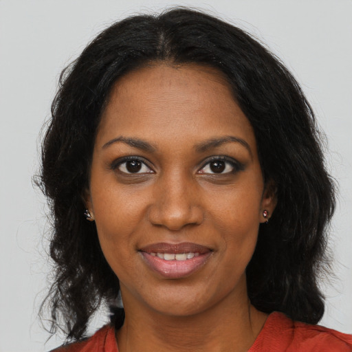 Joyful black young-adult female with long  brown hair and brown eyes