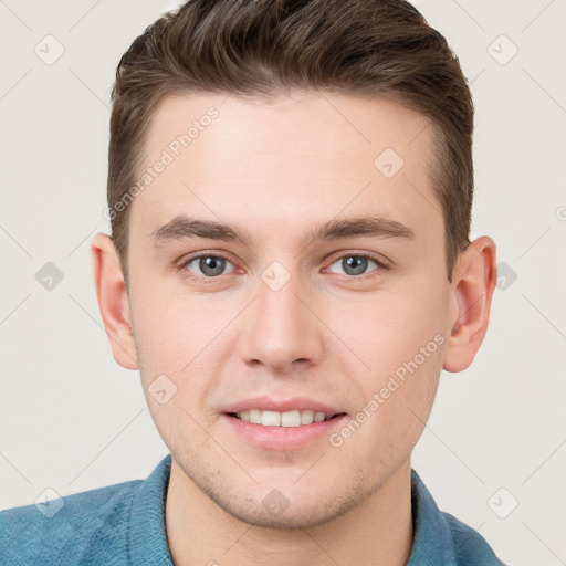 Joyful white young-adult male with short  brown hair and grey eyes