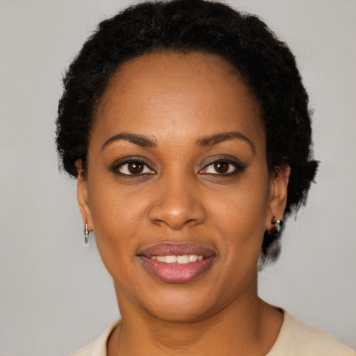 Joyful black young-adult female with short  brown hair and brown eyes