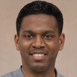 Joyful latino young-adult male with short  black hair and brown eyes