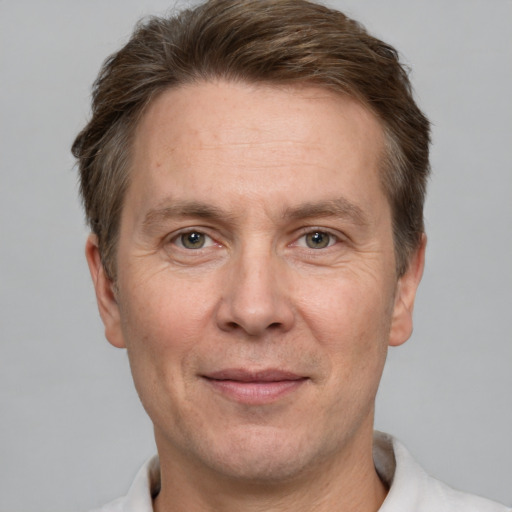 Joyful white adult male with short  brown hair and grey eyes