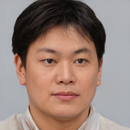 Joyful asian young-adult male with short  brown hair and brown eyes
