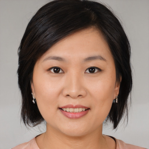 Joyful asian young-adult female with medium  brown hair and brown eyes