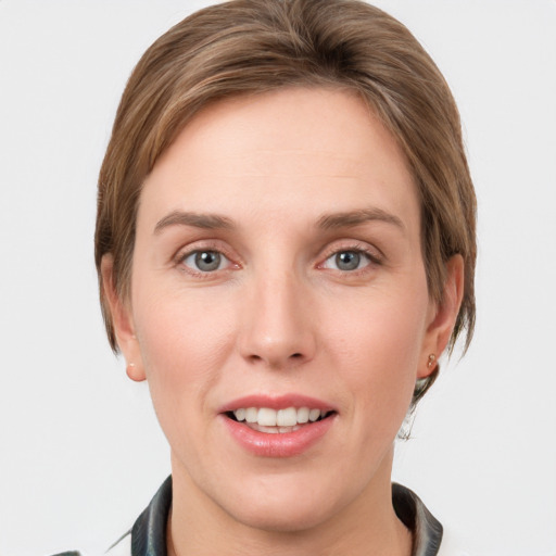 Joyful white young-adult female with medium  brown hair and grey eyes