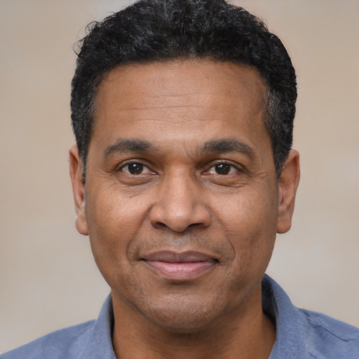 Joyful latino adult male with short  black hair and brown eyes