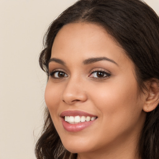 Joyful white young-adult female with long  brown hair and brown eyes