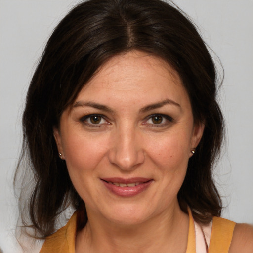 Joyful white adult female with medium  brown hair and brown eyes