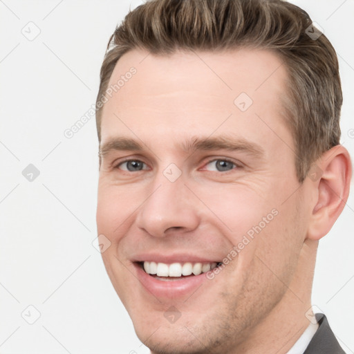 Joyful white young-adult male with short  brown hair and grey eyes