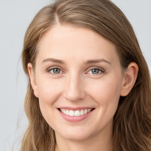 Joyful white young-adult female with long  brown hair and grey eyes