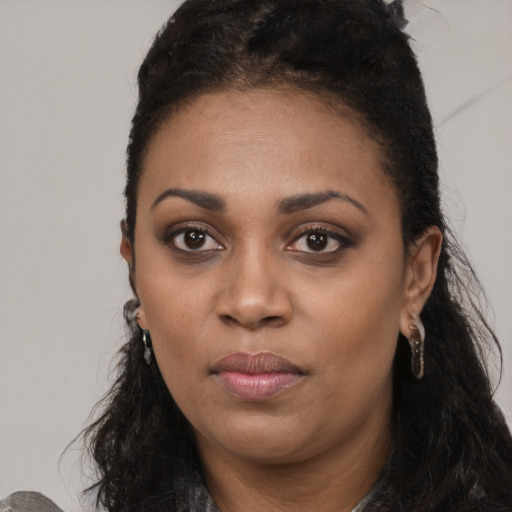 Joyful black young-adult female with long  black hair and brown eyes