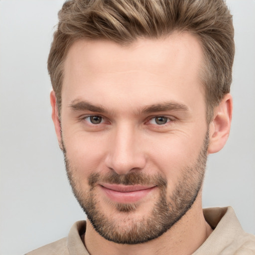 Joyful white young-adult male with short  brown hair and grey eyes