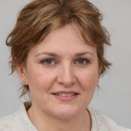 Joyful white adult female with medium  brown hair and blue eyes