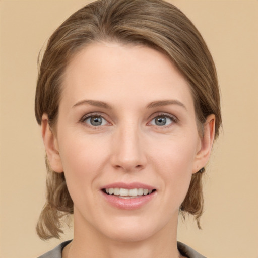 Joyful white young-adult female with medium  brown hair and grey eyes