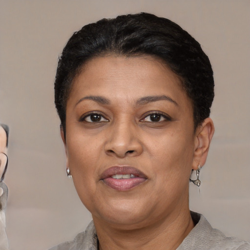 Joyful black adult female with short  black hair and brown eyes